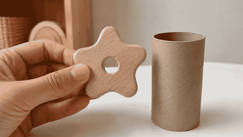 Parent demonstrating the toilet paper roll choking hazard safety test for toddler toys