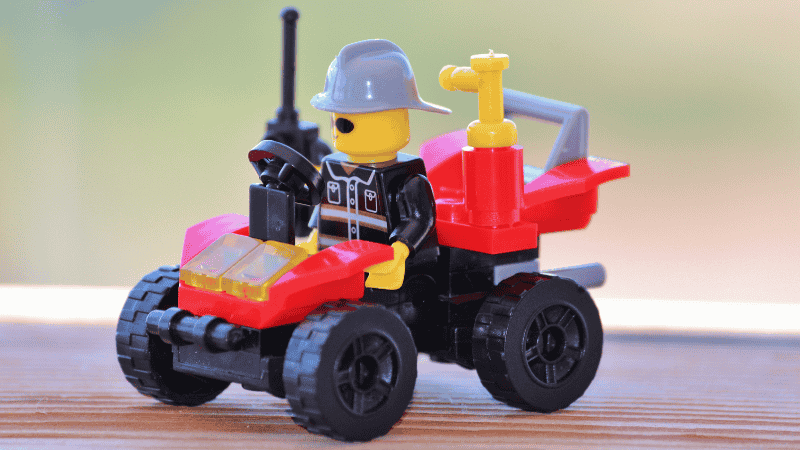 A completed LEGO 4+ Fire Truck sitting on a play table, clearly showing the large, easy-to-build "Starter Brick" chassis designed for small hands.