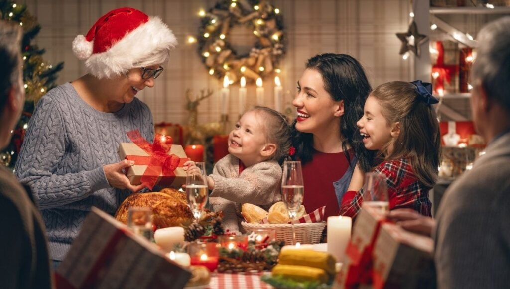 A 3-year-old child reaching excitedly toward a wooden toy just unwrapped on Christmas morning surrounded by gifts in front of a decorated tree with warm golden lights